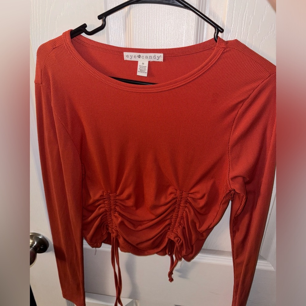 Long sleeve M Eye Candy shirt with scrunched ties at the bottom.